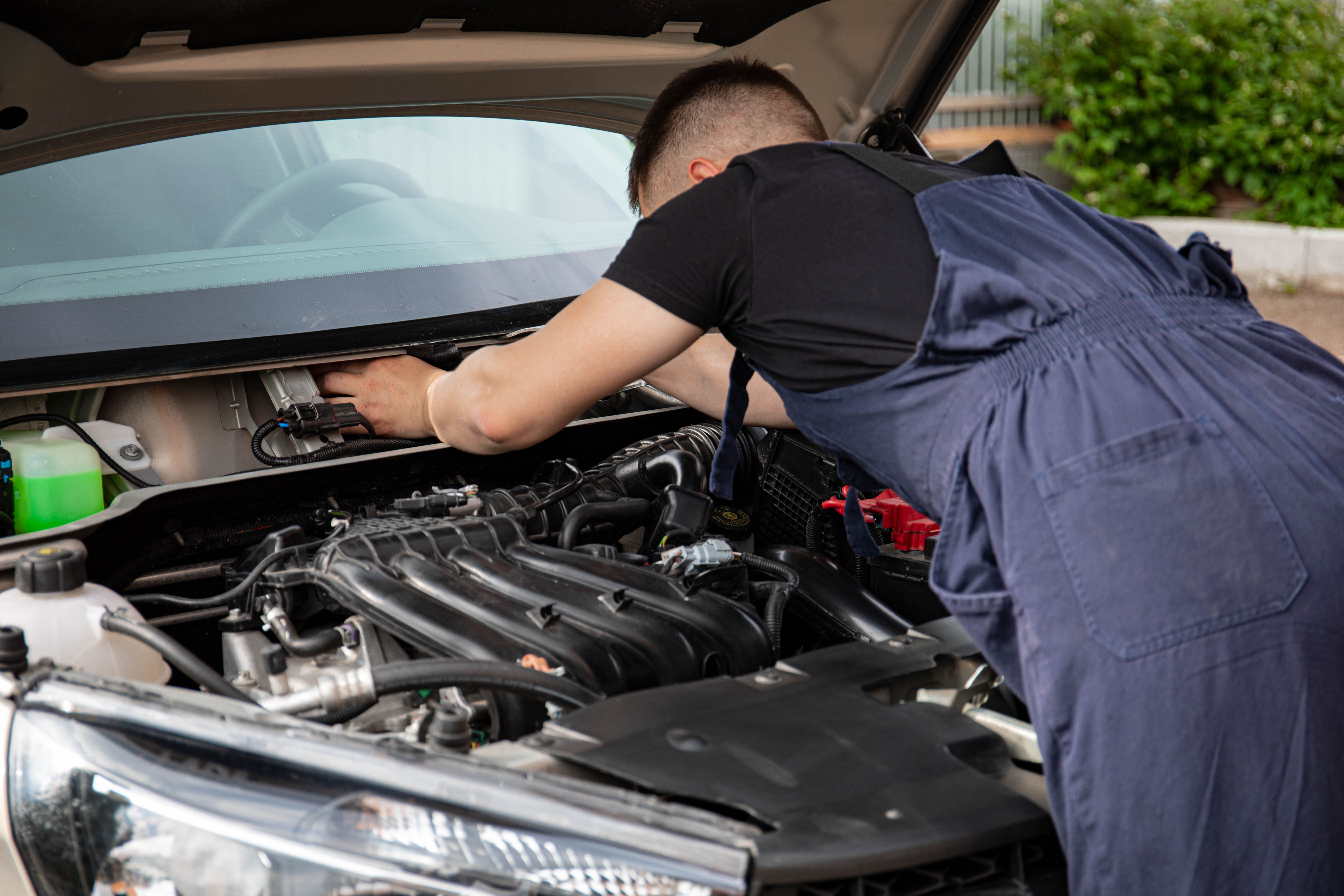 Technician fitting a new battery to a Omoda in Jumeirah
